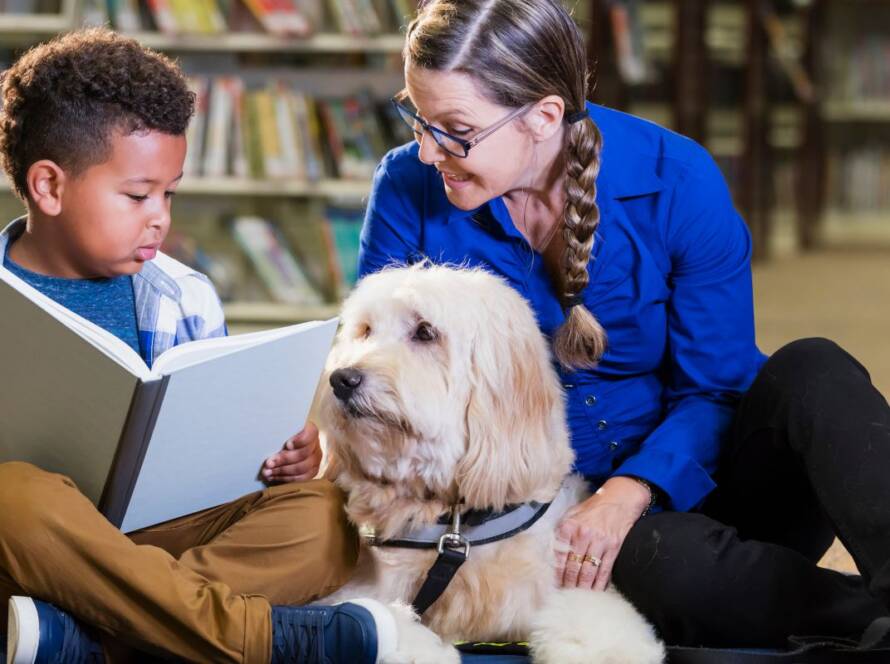 therapy dog working with a child in a library